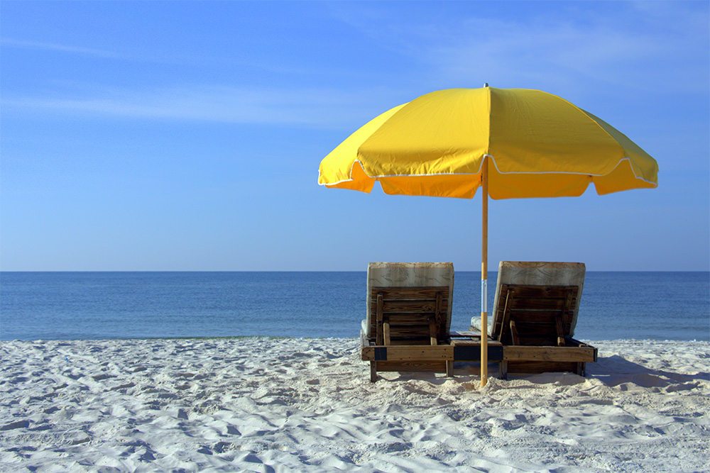 Deux chaises longues et un parasol devant la mer 
